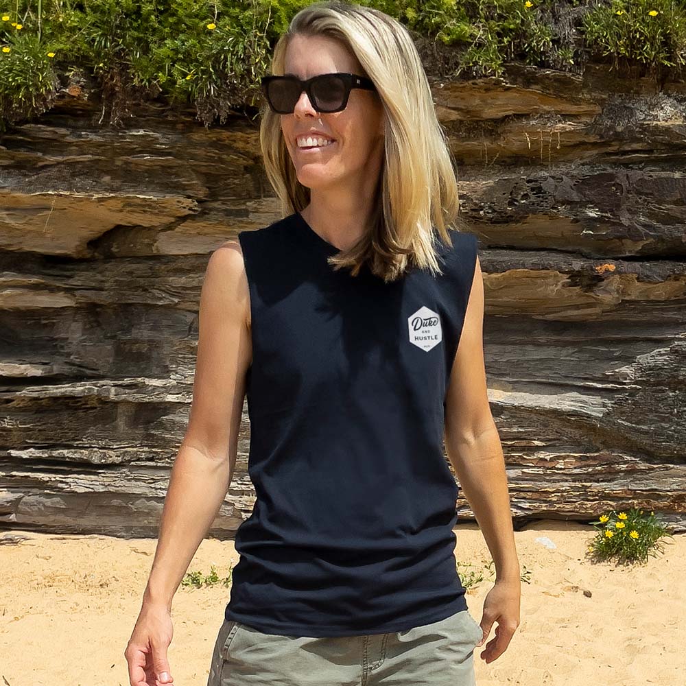 Ash in the Women’s muscle tank, with raw arm holes, in navy